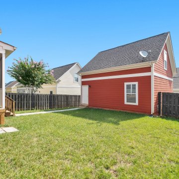 fenced in backyard with a red shed